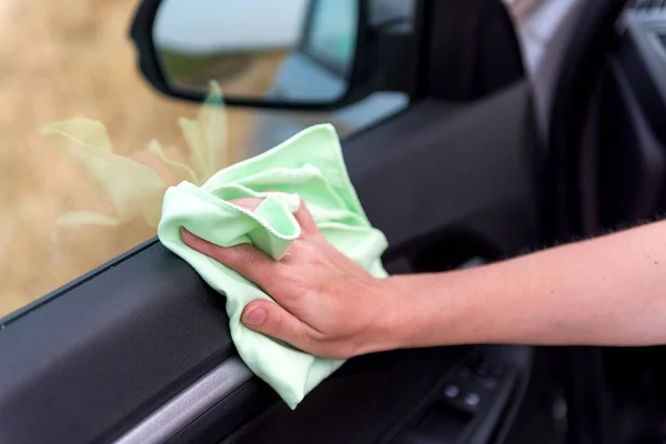 Een vrouwelijke hand met een microfiber doek reinigt de kunststof deur-pa — Stockfoto