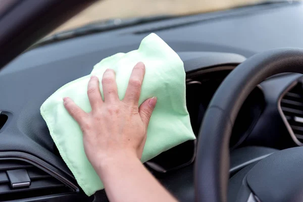 Een vrouwelijke hand met een microvezeldoek reinigt het kunststof paneel een — Stockfoto