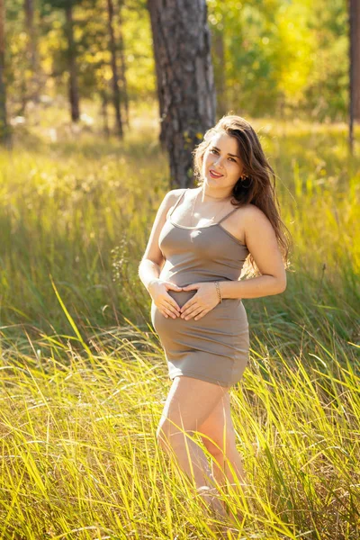 Portret van een mooi jong zwanger meisje in een modieuze dre — Stockfoto