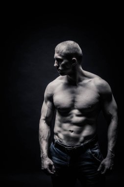 bir erkek vücut geliştirmeci portresi, siyah bir zemin üzerine spor teşkil etmektedir kaslarını zorlayarak izole edilmiştir. tek renkli. Bir fotoğraf rekabet spor, sağlık, fitness kavramı