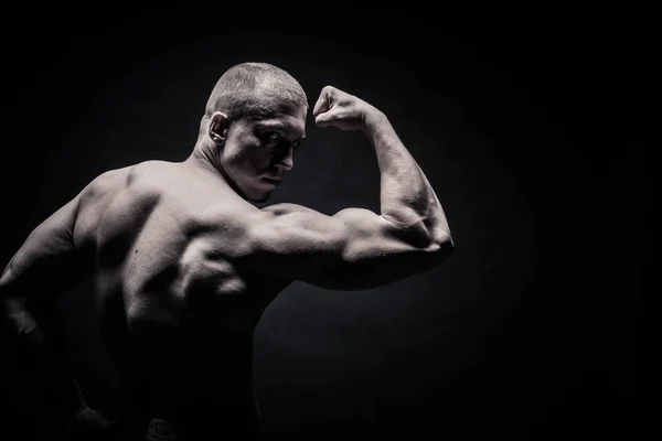 Porträtt av en manliga kroppsbyggare, anstränga musklerna i sport utgör — Stockfoto