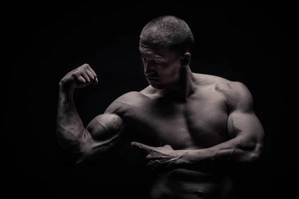 Portrait of a male bodybuilder, straining muscles in sports pose — Stock Photo, Image