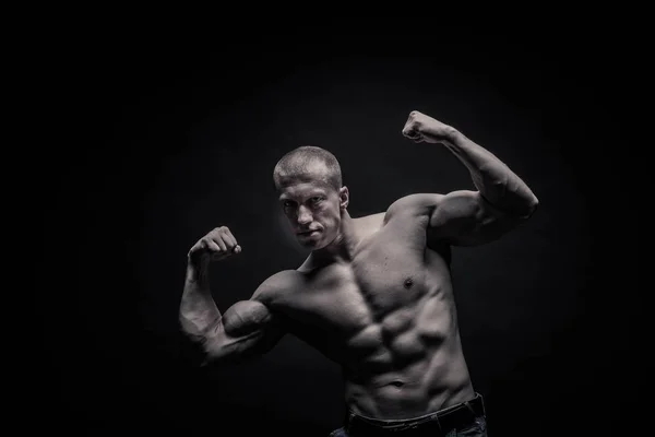 Retrato de un culturista masculino, tensando los músculos en pose deportiva —  Fotos de Stock