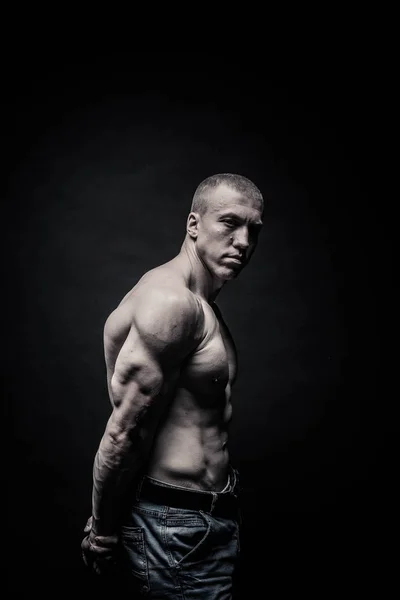 Портрет чоловіка-бодібілдера, напружує м'язи в спортивній позі — стокове фото