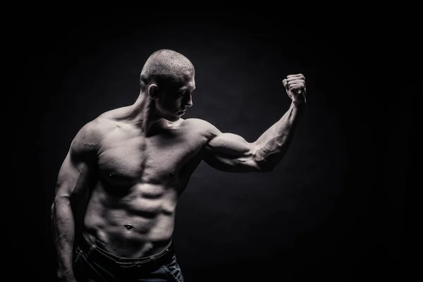 Porträtt av en manliga kroppsbyggare, anstränga musklerna i sport utgör — Stockfoto