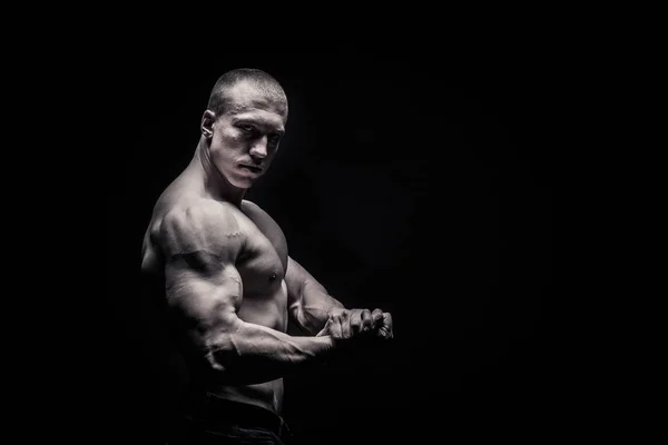 Retrato de un culturista masculino, tensando los músculos en pose deportiva — Foto de Stock