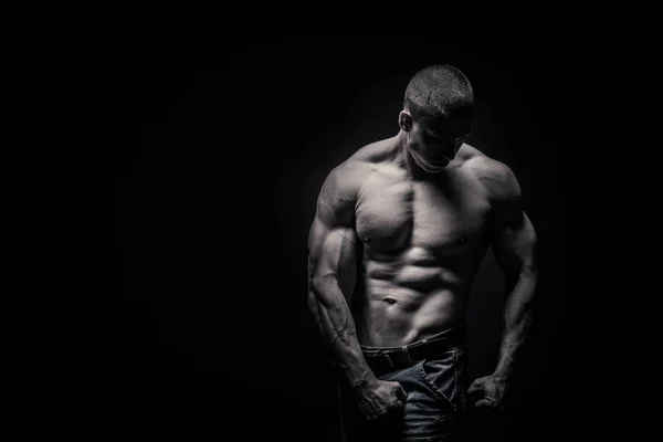 Ritratto di un bodybuilder maschio su uno sfondo nero isolato. m Foto Stock