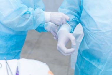 Doktor asistanı steril lateks eldiven giy yardımcı olur