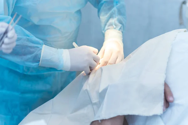 The hands of the surgeon and assistant physician doing surgery i