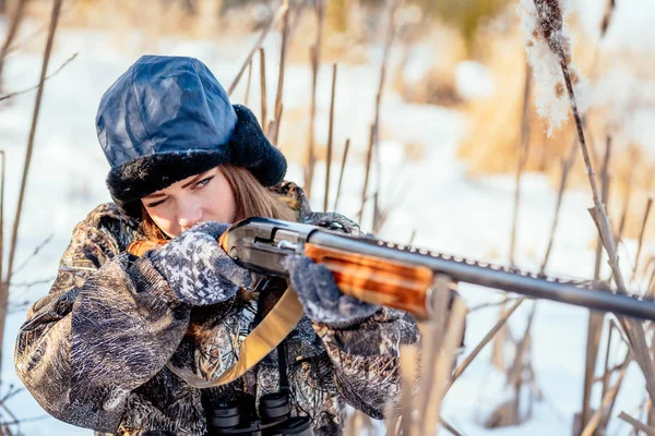 Женщина-охотник в камуфляжной одежде готова к охоте, держа пистолет — стоковое фото
