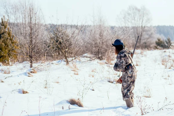 Женщина-охотник в камуфляжной одежде готова к охоте, держа пистолет — стоковое фото