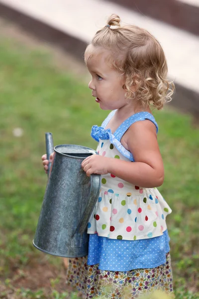 Fleißiges süßes kleines Mädchen, das Blumen im Sommergarten gießt, — Stockfoto