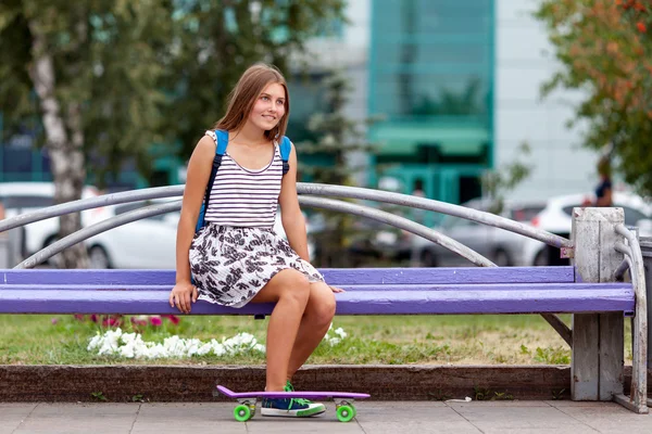 Mujer joven agradable y de moda posando con monopatín — Foto de Stock