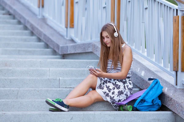 Merdivenlerde oturan smartphone ile güzel, mutlu genç kız. — Stok fotoğraf