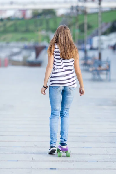 Junge süße Schulmädchen fährt Skateboard auf der Straße — Stockfoto