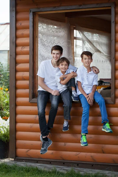 Retrato de meninos bonitos felizes no fundo da casa de madeira — Fotografia de Stock