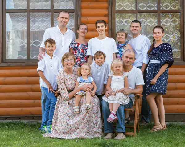 Portrait of big nice happy family on background of wooden house — Stock Photo, Image