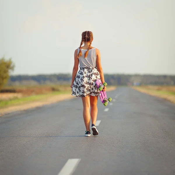 Young cute girl rides skateboard on road — Stock Photo, Image