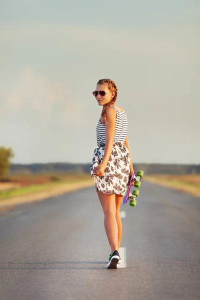 Young cute girl rides skateboard on road — Stock Photo, Image