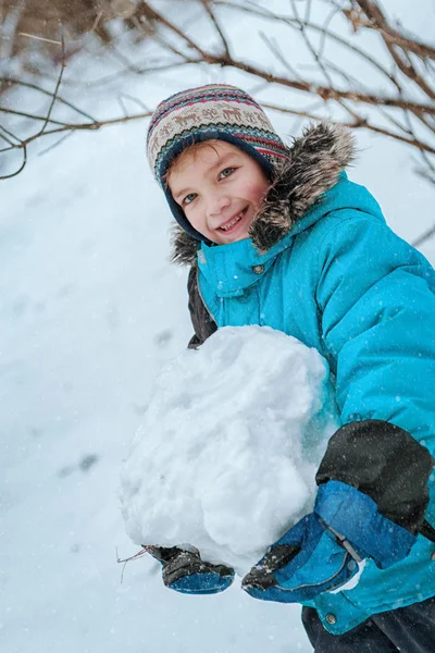 Веселый счастливый мальчик играет в зимнем парке , — стоковое фото