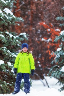 Neşeli mutlu çocuk kış parkta oynarken,