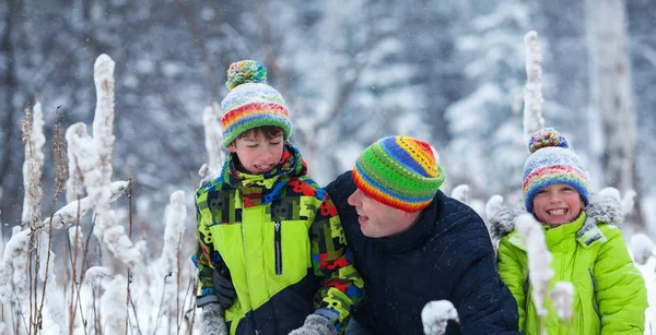 Portret van een gelukkig gezin in winter park. Vader, zoon en dochtertje lachen — Stockfoto
