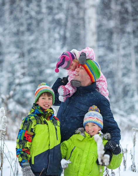 Portrait d'une famille heureuse dans un parc d'hiver. Père, fils et petite fille riant — Photo