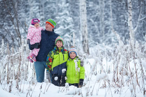 一个幸福的家庭，在冬季公园的画像。父亲、 儿子和小女儿笑 — 图库照片