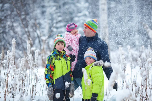 Retrato de una familia feliz en el parque de invierno. Padre, hijo e hija riéndose — Foto de Stock