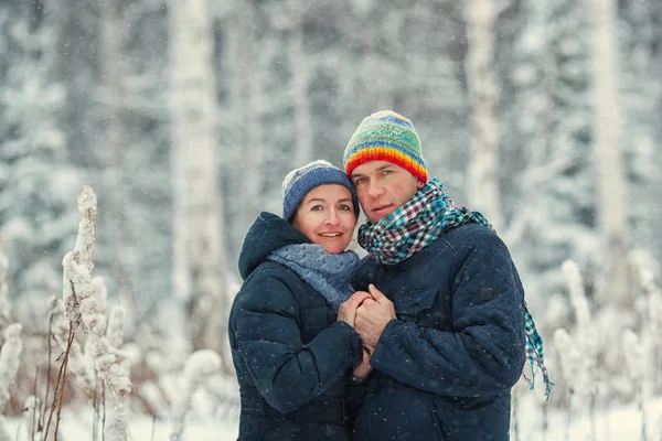 Portret van een mooie gelukkig paren in de winter woud. Man en vrouw die lacht. — Stockfoto