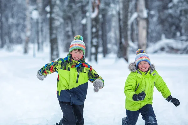 Veselý šťastný chlapce hrající v destinaci winter park, — Stock fotografie