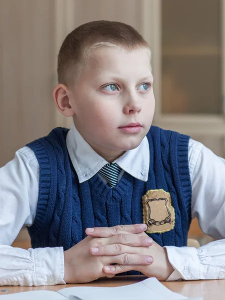 Fleißiger Schüler sitzt am Schreibtisch, Klassenzimmer — Stockfoto