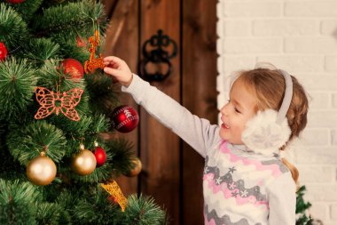 Küçük çocuğun yanında Noel ağacı.