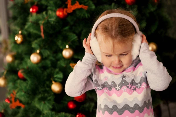 Hübsches kleines Kind in der Nähe des Weihnachtsbaums. — Stockfoto