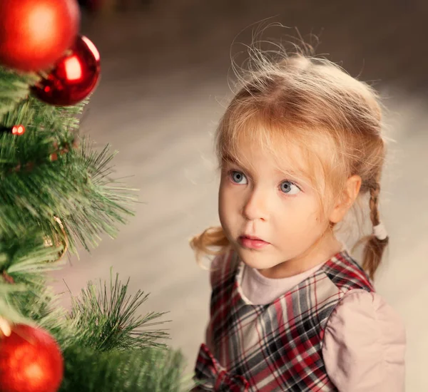 Pretty little child near Christmas tree. — Stock Photo, Image
