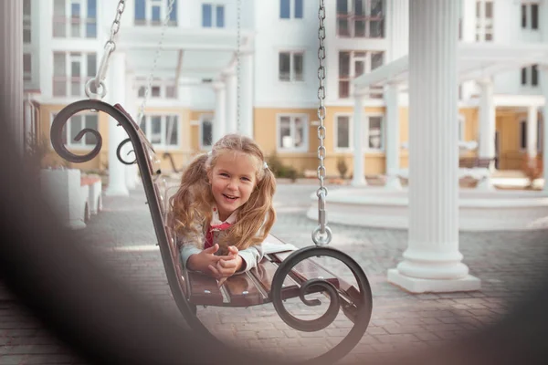 Happy is girl liegt auf einer Holzschaukel im Hof des Hauses. Draußen, Sommer. Porträt — Stockfoto