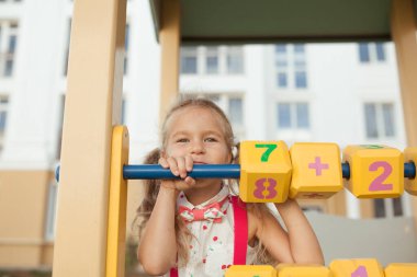 Güzel küçük kız saymayı öğreniyor, anaokulundaki anaokulu öğrencisi oyun alanında.