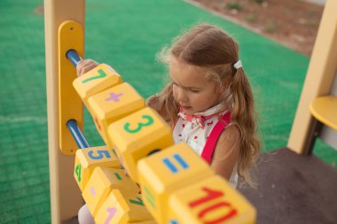 Güzel küçük kız saymayı öğreniyor, anaokulundaki anaokulu öğrencisi oyun alanında.