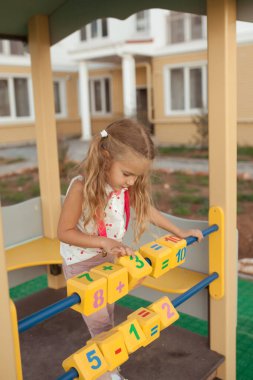 Güzel küçük kız saymayı öğreniyor, anaokulundaki anaokulu öğrencisi oyun alanında.