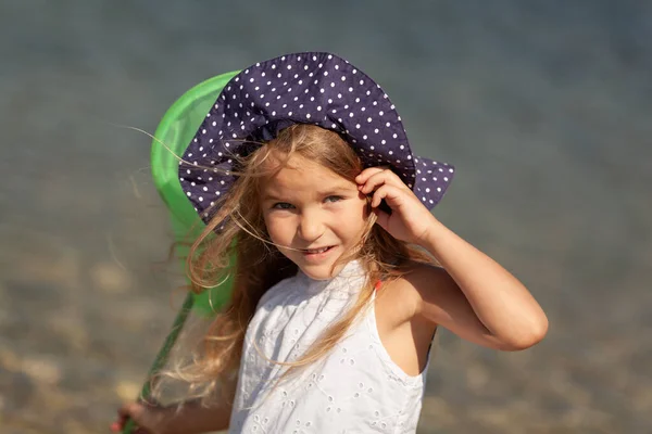Retrato de linda chica alegre, feliz con sombrero, al aire libre. Chica de pie en la orilla del mar . — Foto de Stock