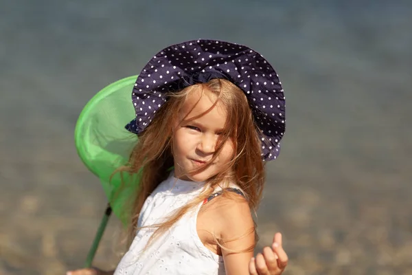 Güzel, neşeli, açık havada şapka takan kız portresi. Deniz kıyısında duran kız. — Stok fotoğraf