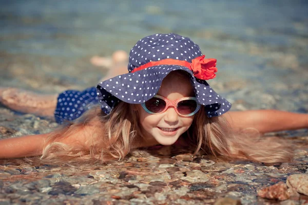 Porträt eines niedlichen, fröhlichen Mädchens mit Hut und Sonnenbrille, im Freien. Mädchen schwimmt im Meer — Stockfoto