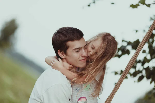 Velký bratr si hraje s mladší sestrou, třese s ní na volantu — Stock fotografie