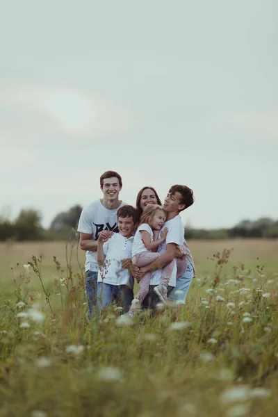 Porträt einer großen glücklichen Familie vor dem Hintergrund der sommerlichen Natur, ein Spaziergang auf dem Feld — Stockfoto