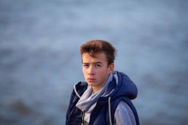 Yakışıklı ve acımasız bir adamın portresi. Deniz kenarında bir genç,