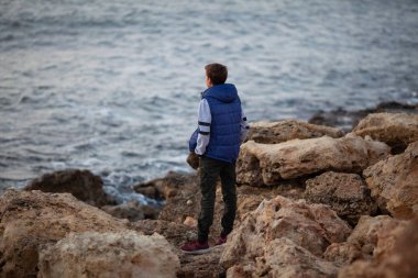 Yakışıklı ve acımasız bir adamın portresi. Deniz kenarında bir genç, dalgaların üzerinde duruyor..