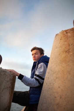 Yakışıklı ve acımasız bir adamın portresi. Deniz kenarında bir genç, dalgaların üzerinde duruyor..