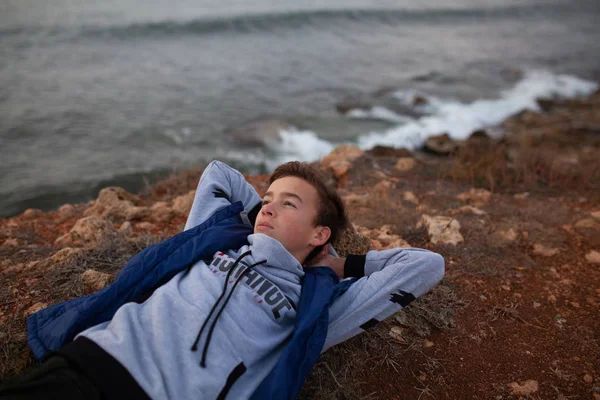 Ritratto di un bel ragazzo serio e brutale. Un adolescente in riva al mare, si trova sulle rive del mare . — Foto Stock