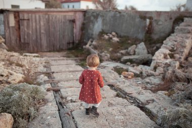 Kırmızı elbiseli güzel bir kızın portresi. Güneşli sonbaharda bir çocuk yürür