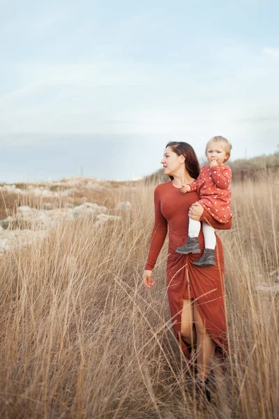 Ein kleines Mädchen und eine Mutter gehen, sie umarmen sich — Stockfoto